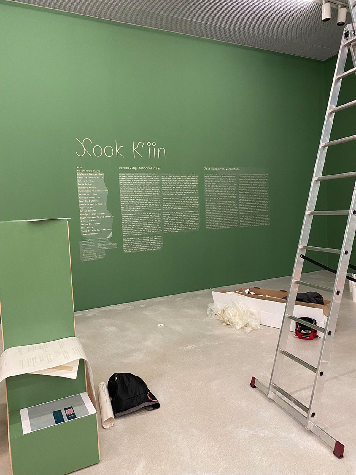 Wandtexte einer Ausstellung auf grüner Wand, geplottete Folie